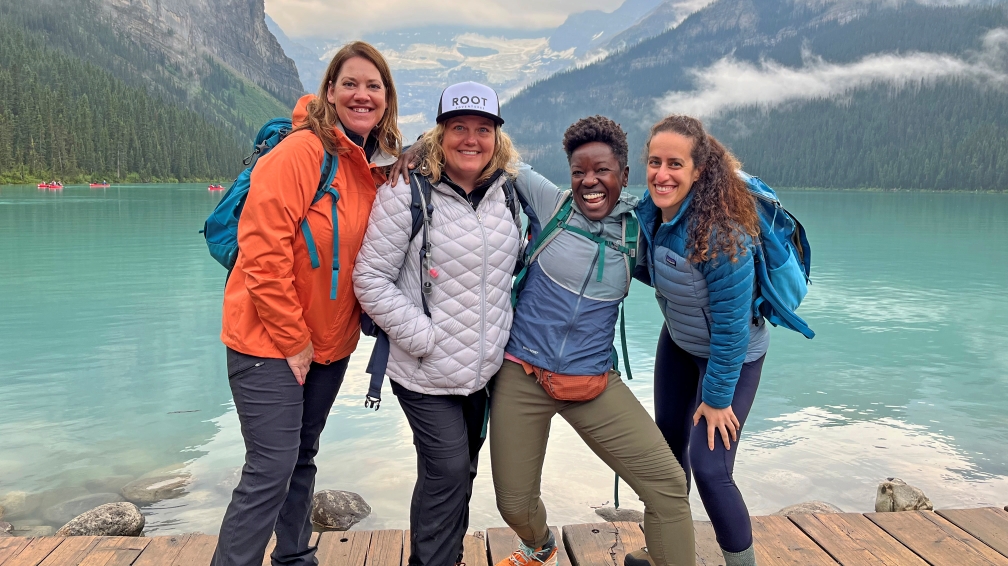 a group of 4 people posing in front of Lake Louise